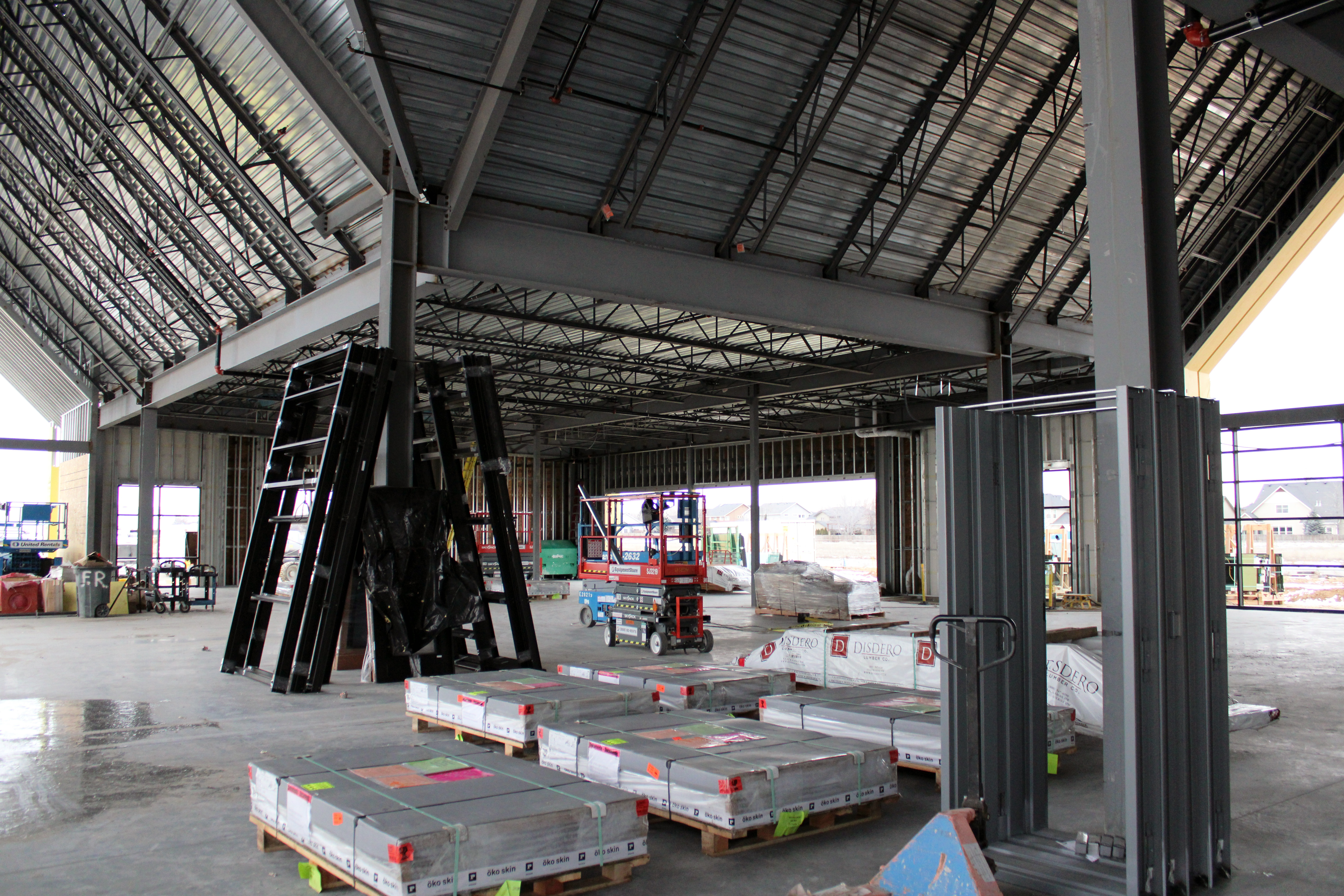 Orchard Park Construction image showing the inside of the building in progress with palettes and ladders