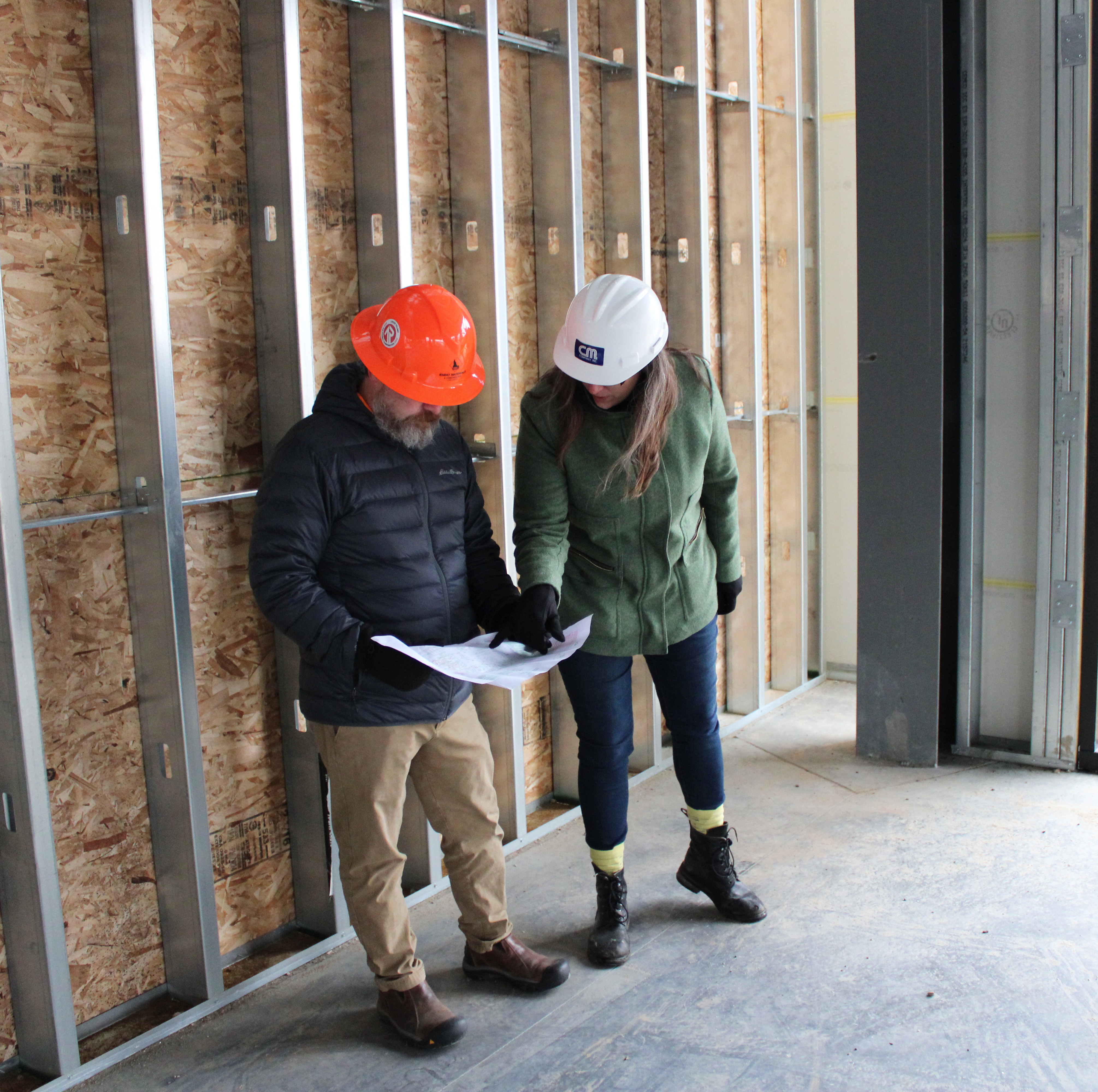 Two construction planners in discussion while looking at plans