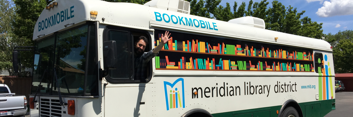 Meridian Library staff member waves out the window of the Bookmobile