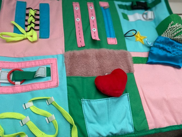 quilted fabric with zippers, pockets, laces and other activities