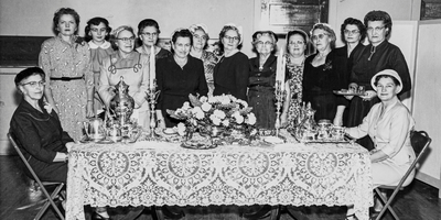 a group of ladies gather at a table for a portrait