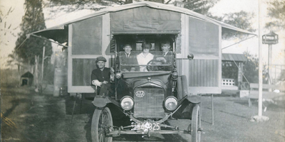 Willett family poses in front of their auto bungalow