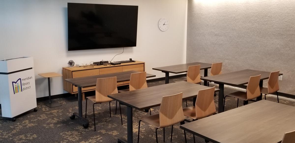 Orchard Park Conference Room includes tables, chairs, a mounted screen, and a whiteboard