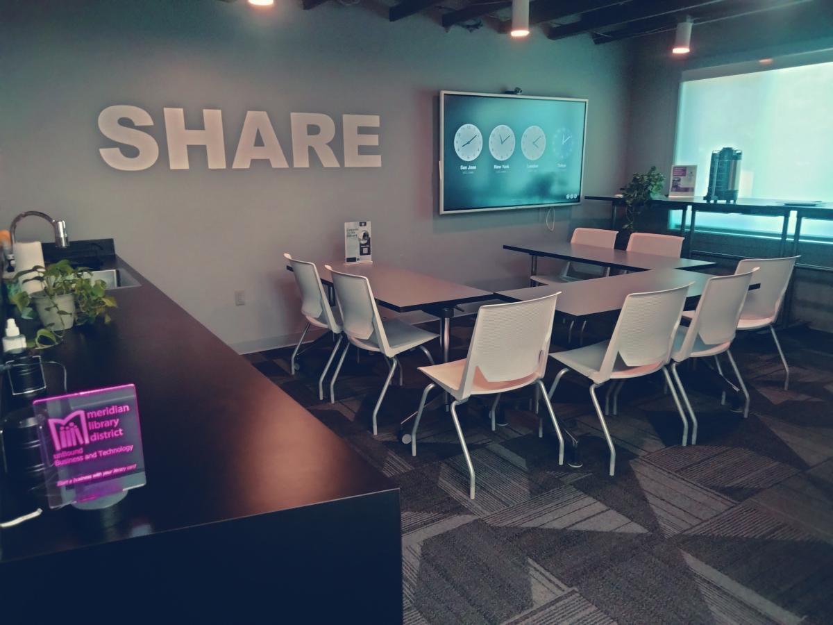 The unBound Share meeting space, with tables, chairs, and a small kitchenette.