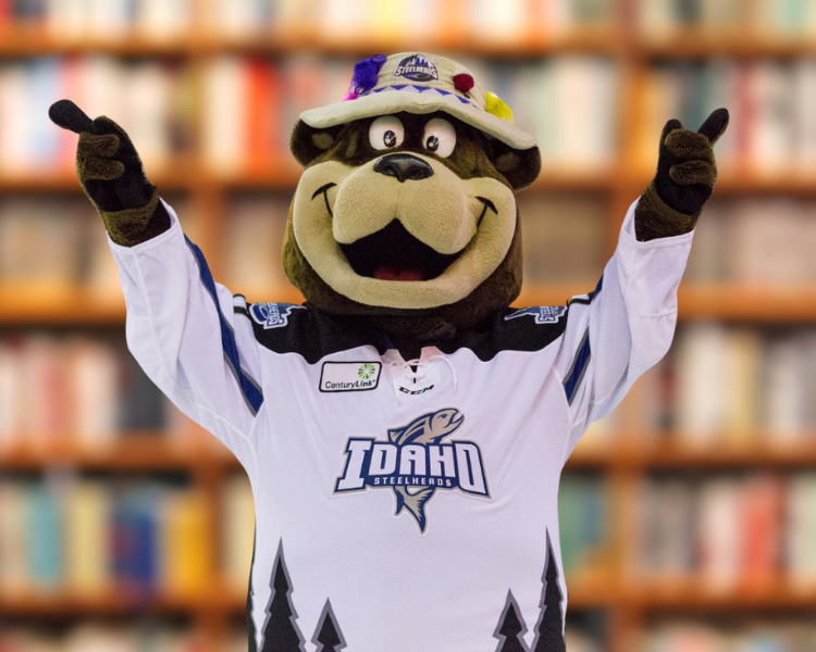 Blue, the Idaho Steelheads mascot, celebrates in front of bookshelves